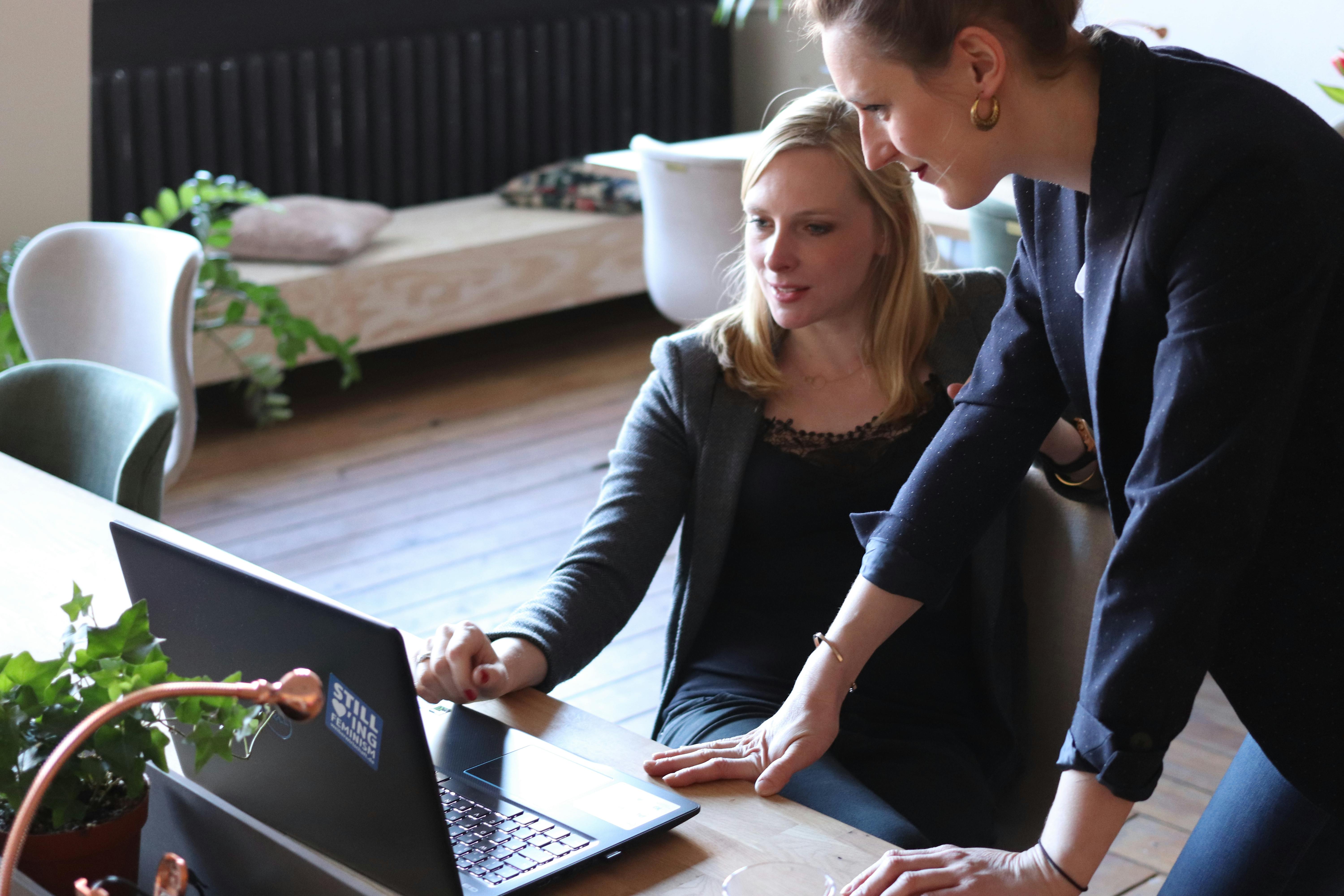 Office workers collaborating around a laptop